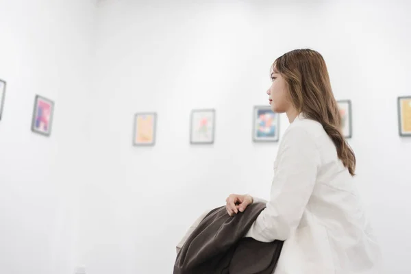 アートギャラリーを訪れる女性美術館でフォトフレーム絵画を見ながら写真を見る人々のライフスタイルコンセプト — ストック写真