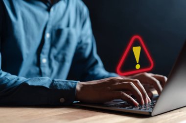 İş adamı veya personel, programcı, bilgisayar dizüstü bilgisayarı kullanarak uyarı hatası ve bakım için üçgen uyarı işareti kullanan geliştirici