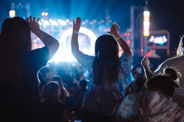 stock image Crowd of hands up concert stage lights and people fan audience silhouette raising hands in the music festival rear view with spotlight glowing effect nightlife event.