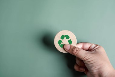 Yeşil Enerji, Yenilenebilir ve sürdürülebilir Kaynaklar. Çevresel ve Ekosistem sistemi, elle tutulan geri dönüşüm simgesi kağıdı arka planda kesilmiş, temiz ekoloji kavramı.