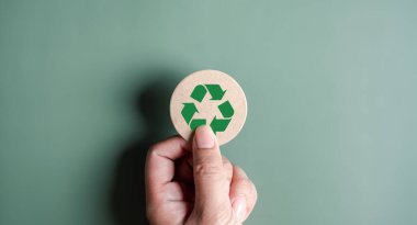 Yeşil Enerji, Yenilenebilir ve sürdürülebilir Kaynaklar. Çevresel ve Ekosistem sistemi, elle tutulan geri dönüşüm simgesi kağıdı arka planda kesilmiş, temiz ekoloji kavramı.