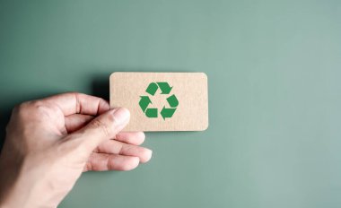 Yeşil Enerji, Yenilenebilir ve sürdürülebilir Kaynaklar. Çevresel ve Ekosistem sistemi, elle tutulan geri dönüşüm simgesi kağıdı arka planda kesilmiş, temiz ekoloji kavramı.