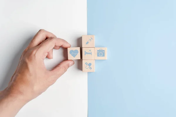 Health insurance concept. people hands putting plus symbol and healthcare medical wooden cube block with icon, health and access to welfare health concept
