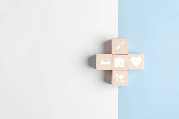 Health insurance concept. plus symbol and healthcare medical wooden cube block with icon, health and access to welfare health concept