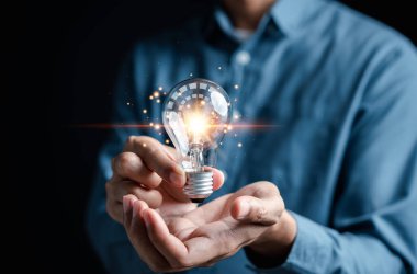 Elindeki ampul, fikir, yenilik ve ilham, parlayan sanal beyin, ampullerle akıllı yaratıcılık, motivasyon ve yenilik kavramı..