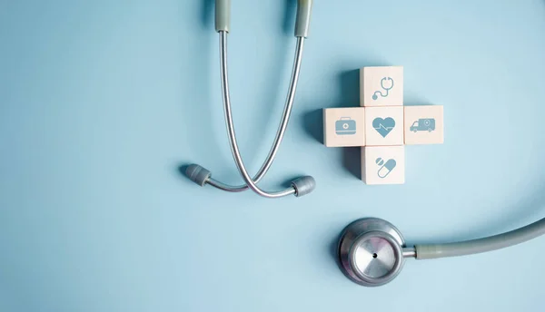 Health insurance concept. plus symbol and healthcare medical wooden cube block with stethoscope, health and access to welfare health.
