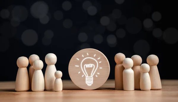 Idea, innovation, motivation planning development leadership and customer target group concept, Wooden figures standing around light bulb for creative objective, target for business investment.