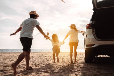Araba yolculuğu yapan mutlu aile. Gün batımında arabada yaz tatili, baba, anne ve kız mutlu seyahatler tatillerde birlikte araba sürmenin keyfini çıkarın, insanların otomobille yolculuk yapmalarının..
