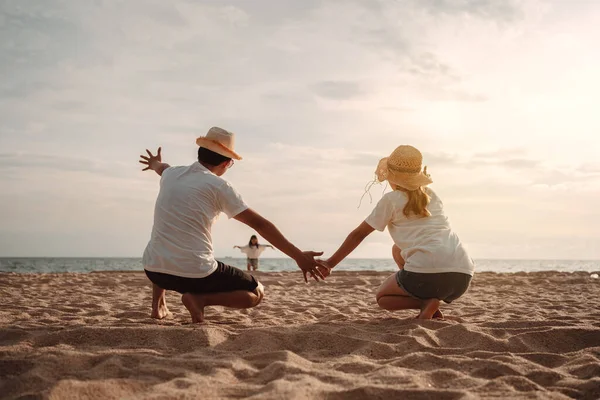 stock image Happy asian family enjoy the sea beach at consisting father, mother and daughter having fun playing beach in summer vacation on the ocean beach. Happy family with vacations time lifestyle concept.