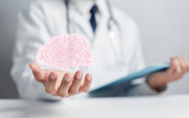 İnsan beyni ikonu tutan doktor, yaratıcı zeka düşüncesi ya da Alzheimer, Parkinson hastalığı, bunama, felç, nöbet ya da akıl sağlığı. Nöroloji ve Psikoloji.