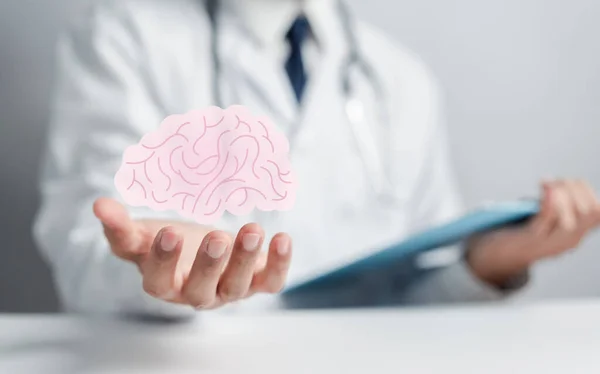 Doctor holding human brain icon, idea creative intelligence thinking or Awareness of Alzheimer, Parkinson\'s disease, dementia, stroke, seizure or mental health. Neurology and Psychology care.