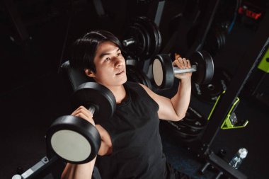 Erkek, spor salonunda halterli vücut geliştirici. Halterle egzersiz yapan vücut geliştirici. Spor eğitimi, sağlıklı vücut geliştirme, sporcu kaslı yaşam tarzı..