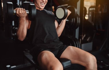 Erkek, spor salonunda halterli vücut geliştirici. Halterle egzersiz yapan vücut geliştirici. Spor eğitimi, sağlıklı vücut geliştirme, sporcu kaslı yaşam tarzı..