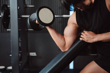 Erkek, spor salonunda halterli vücut geliştirici. Halterle egzersiz yapan vücut geliştirici. Spor eğitimi, sağlıklı vücut geliştirme, sporcu kaslı yaşam tarzı..