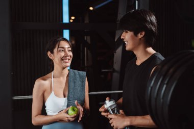 Sporcu ve kadın sporcuların spor eğitiminden sonra spor salonunda egzersiz yapıp spor yaptıktan sonra halterlerle spor yaptıktan sonra sağlıklı bir vücut geliştirme..