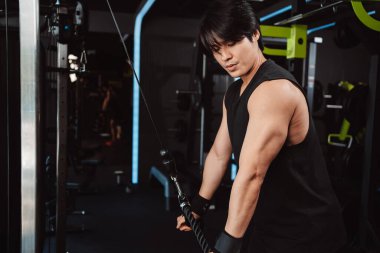 Spor salonundaki halterleri kaldırarak ağırlık çalıştıran bir adam. Fitness kaslı vücut kilo kaybı. Vücut geliştirme sağlıklı yaşam tarzı.