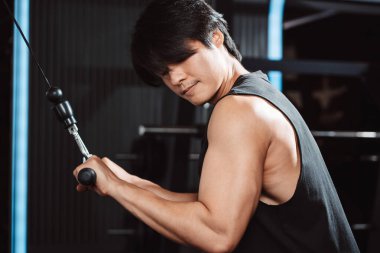 Spor salonundaki halterleri kaldırarak ağırlık çalıştıran bir adam. Fitness kaslı vücut kilo kaybı. Vücut geliştirme sağlıklı yaşam tarzı.