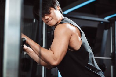 Spor salonundaki halterleri kaldırarak ağırlık çalıştıran bir adam. Fitness kaslı vücut kilo kaybı. Vücut geliştirme sağlıklı yaşam tarzı.