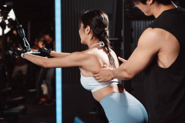 Vücut geliştiren kadın spor salonunda ağırlık kaldırmak için antrenörlük yapıyor. Vücut geliştirici halterle egzersiz yapıyor. spor eğitimi sağlıklı vücut geliştirme.