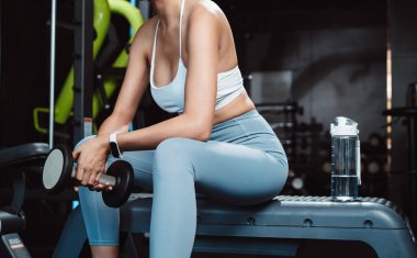 Vücut geliştiren kadın spor salonunda halterli ağırlık çalışıyor. Vücut geliştirici halterle egzersiz yapıyor. Spor eğitimi, sağlıklı vücut geliştirme, sporcu kaslı yaşam tarzı..