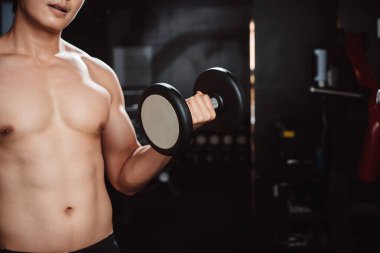 Erkek, spor salonunda halterli vücut geliştirici. Halterle egzersiz yapan vücut geliştirici. Spor eğitimi, sağlıklı vücut geliştirme, sporcu kaslı yaşam tarzı..