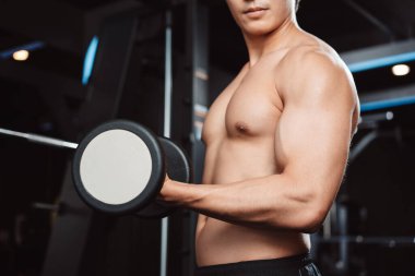Erkek, spor salonunda halterli vücut geliştirici. Halterle egzersiz yapan vücut geliştirici. Spor eğitimi, sağlıklı vücut geliştirme, sporcu kaslı yaşam tarzı..