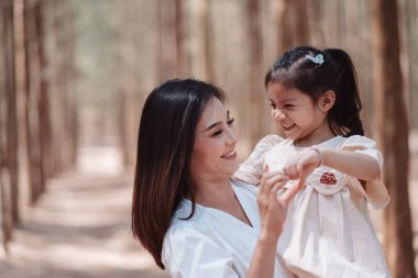 Mutlu aile, anne, tatlı kız ormanda çimen tarlasında aşk duygusunun tadını çıkarıyor..