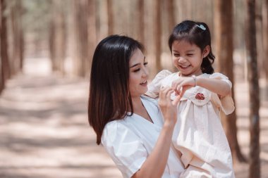 Mutlu aile, anne, tatlı kız ormanda çimen tarlasında aşk duygusunun tadını çıkarıyor..