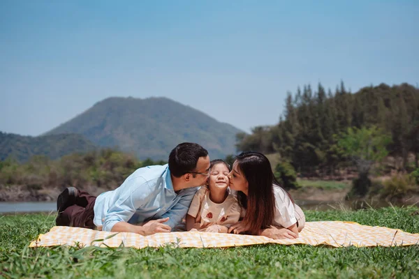 stock image Happy family in the nature travel. family on weekend playing together in the meadow with river Parents hold the child and daughter hands.health life insurance plan concept.