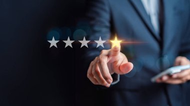 Müşteriler, iş adamlarının 5 yıldızlı puanlarını akıllı telefonlardan seçiyor ve 5 yıldızlı bir sembol veriyorlar. Mükemmel reyting. Kullanıcı derecelendirme, geri bildirim, iyi iş ağı puanı.