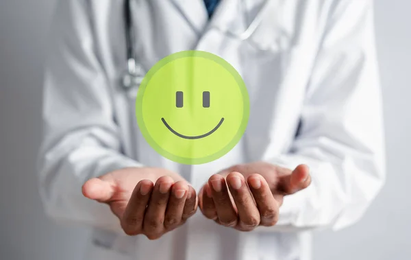 Doctor holding virtual Smile icon, health care good service, satisfaction of hospital and clinic service concept.
