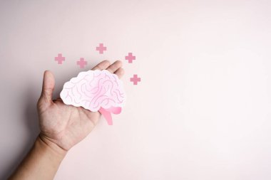 İnsan beyni simgesi kağıt kesiği, yaratıcı zeka düşüncesi ya da bilinç bunaması, felç, nöbet ya da akıl sağlığı ile el ele tutuşmalar. Nöroloji ve Psikoloji.