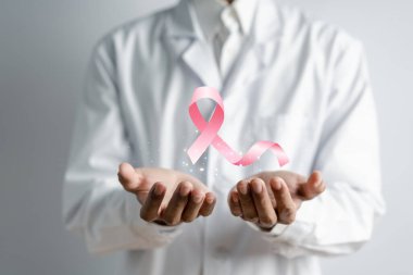 Doktor elinde sanal pembe kurdele kanseri, göğüs kanseri farkındalığı ve sağlık kontrolü konsepti tutuyor..