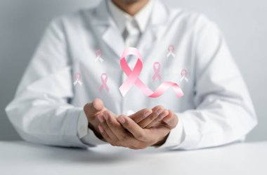 Doktor elinde sanal pembe kurdele kanseri, göğüs kanseri farkındalığı ve sağlık kontrolü konsepti tutuyor..