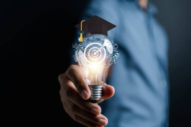 Eğitimli ve mezuniyet konsepti olan ampulü tutan bir adam. Yaratıcı düşünce ve problem çözme çözümü hakkında bilgi edinmek, e-öğrenim çevrimiçi eğitim diploması