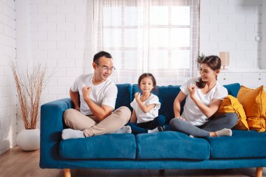 Ebeveynler ve kızlarından oluşan aile evde mutlu bir şekilde egzersiz yapıyor. Esneklik için, kas gücü geliştirmek için, Spor Antrenmanı ailesini birlikte çalıştırmak için..