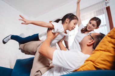 Ebeveynler ve kızlarından oluşan aile evde mutlu bir şekilde egzersiz yapıyor. Esneklik için, kas gücü geliştirmek için, Spor Antrenmanı ailesini birlikte çalıştırmak için..