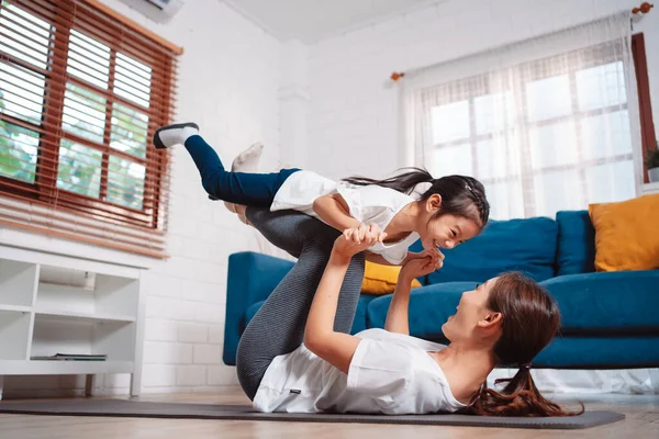 stock image Mother and daughter exercising together happily at home. for flexibility build muscle strength, Sport workout training family together concept.