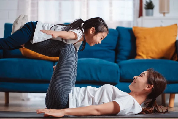 stock image Mother and daughter exercising together happily at home. for flexibility build muscle strength, Sport workout training family together concept.