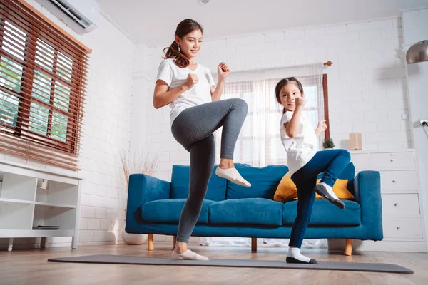 stock image Mother and daughter exercising together happily at home. for flexibility build muscle strength, Sport workout training family together concept.