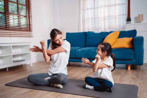 stock image Mother and daughter exercising together happily at home. for flexibility build muscle strength, Sport workout training family together concept.