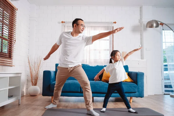 stock image Father and daughter exercising together happily at home. for flexibility build muscle strength, Sport workout training family together concept.