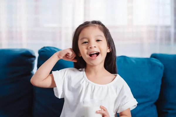 Stock image Cute Asian girl drinking milk at home to nutrition vitamin healthy and strong teeth.