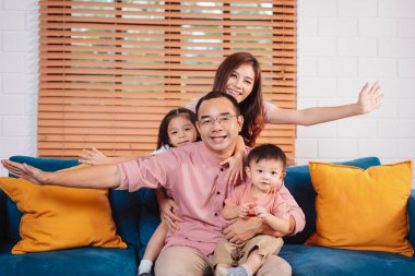 Mutlu Asyalı aile hafta sonu eğleniyor. Kanepede birlikte oynuyoruz.. 