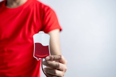 Hands holding blood drop paper cut, blood transfusion, world blood donor day, red cross to give blood.world hemophilia day concept.	