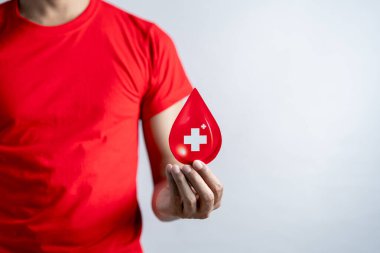 Hands holding blood drop paper cut, blood transfusion, world blood donor day, red cross to give blood.world hemophilia day concept.	