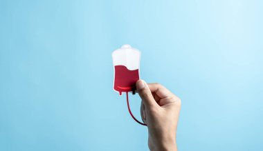 Hands holding blood drop paper cut, blood transfusion, world blood donor day, red cross to give blood.world hemophilia day concept.	