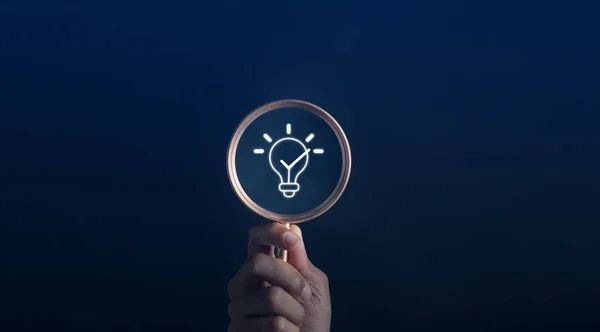 stock image Magnifying glass focus to light bulb icon which for mind, creative, idea, innovation, motivation planning development leadership and customer target group concept.