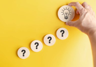 Hand hold wood block to smart creativity light bulb which among question icon. smart, creative, idea thinking to innovation brainstorm and imagination learning educate solution concept.	