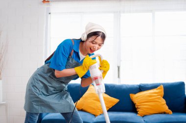 Happy Housework ya da ev hizmetçisi kadın şarkı söyleyip tozları temizliyor, küçük işletmeleri temizliyor. profesyonel ekipman eski evi temizliyor.
